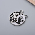 Macro shot of Yin Yang wolf charms featuring black and white enamel finish for DIY jewelry - Double Dragon Tai Chi