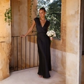 Elegant black satin V-neck mermaid maxi dress for parties, shown on a sunlit balcony - Black