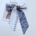 Blue and white floral silk hair scarf ribbon styled as a bow on a fashion magazine - Blue Flower