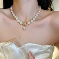 Détail d'un collier de perles plaqué or avec pendentif DD en cristal sur un mannequin - DD Letter Pearl Necklace / Or