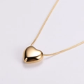 Collana con ciondolo a cuore in oro lucido con catena a serpente su grigio - Oro