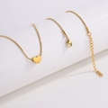 Detalle del collar con colgante de corazón dorado y cadena de serpiente en soporte - Collar de Corazón de Oro