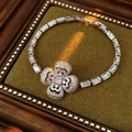 Detail of silver clover bracelet with sparkling clear zircon stones on green velvet pad - Bracelet - Silver
