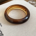 Macro detail of amber marbled acrylic resin bangle with thick polished round design - Thickened Round Style / Amber Marble