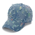Close-up of distressed denim baseball cap featuring colorful embroidery under ripped holes - Light Blue