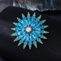 Makroaufnahme der blauen Kristall-Schneeflockenbrosche mit Marquise-Steinen auf Stoff - Seeblau