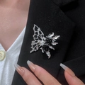 Detailed shot of a gothic silver butterfly brooch with black roses on a suit lapel - Hollow Wing Black Rose Brooch (7244)