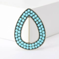 Detailed close-up of water drop brooch with antique bronze frame and turquoise blue beads - Turquoise Blue