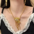 Close-up of surrealist gold weeping eye pendant necklace and earring jewelry set - Tearful Eye Gold Necklace