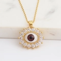 Macro shot of sunburst evil eye pendant with brown center and pave zircon stones - Dark Red