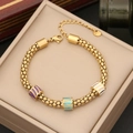 Dettaglio del bracciale dorato con perle smaltate viola, blu e bianche in scatola regalo - Stile 7 Perline Cilindriche a Righe
