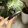 Hand-held close-up of a minimalist black shark hair claw clip in a stylish home setting - Matte Black