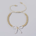 Adjustable beige woven rope bracelet with gold beads and white crystal butterfly bow charm - Beige Braided White Bead Bow (JS-B24022901E)
