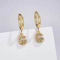 Close-up of golden letter G pendant with sparkling cubic zirconia on stainless steel earring - Letter G (Style: 0229)
