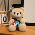 Plüsch-Abschlussbär in Braun mit blauem Kleid und schwarzem Doktorhut für Absolventen - Kamelfarbener Bär-Himmelblaue Kleidung / 18cm