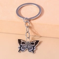 Detail of dark butterfly keychain with skull wing patterns in black enamel finish - Skeleton Bone Butterfly