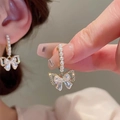 Detailed view of luxury bowknot pearl earrings with sparkling zircon butterfly accents - Gold Pearl Chain Butterfly Charm Ear Hooks