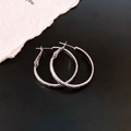 Dettaglio di orecchini d'argento con finitura polvere di stelle e design tondo geometrico - Diametro 30MM / Argento