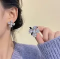 Makroaufnahme von blauen Kristall-Blumenohrsteckern mit funkelnden Zirkonia-Akzenten - Silber Pavé Zirkon Vierblättrige Blumenohrringe (9# Silbernadel-Grau)