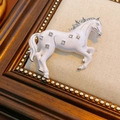 Détail d'une broche cheval vintage en émail blanc ornée de strass brillants de luxe - Or-Blanc
