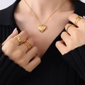 Goldenes Herz-Halskette mit Sternkristall und Set aus Ringen an einem Modell getragen - Gold