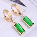 Macro shot of gold rectangle emerald earrings with geometric green step-cut gemstones - Gold Earrings