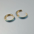 Detailopname van gouden roestvrijstalen oorringen met een blauw emaille verloop effect - 1.6x12mm / Blauw