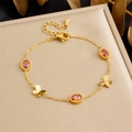 Golden bracelet with orange oval stones and butterfly charms on a jewelry box - Orange-Red Oval Stone Butterfly Style (B1768)