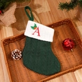 Green knitted Christmas stocking with white cuff and red embroidered letter A detail - Letter A