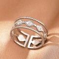 Macro shot of silver-colored triple-layer braided adjustable ring on gold silk background - Silver Triple Eye (C1478)