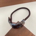 Brown elastic hair tie with curved tortoiseshell resin accent and gold text logo - Blue Brown