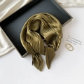 Detailed texture of olive green pleated silk scarf displayed on a black tray - 70*70cm / Pleated Army Green