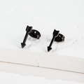 Detailed view of matte black arrow stud earrings in stainless steel on white stone - Arrow / Black