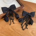 Dettaglio di orecchini a fiocco nero con nappe di perline di cristallo e fiori - Orecchini con perno in argento 925 / Nero