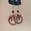 Detailed view of vintage bronze butterfly earrings with hollow pattern and dark brown beads - Antique Rose Gold Butterfly Style