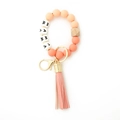 Close-up of MAMA silicone bead keychain bracelet with leather tassel and wood bead - Peach