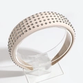 Detail view of beige lychee leather headband featuring studded silver rivets decoration - Beige