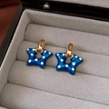 Macro shot of dark blue star-shaped earrings with white polka dots and gold accents - 9# Silver Needle Gold Blue Star