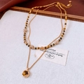 Detail of 18k gold plated tiger eye bead and pearl layered necklace on white fabric - Double Layer Gold Plated Style / Gold/Coffee