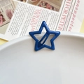Star-shaped metal hair clip in matte dark blue finish shown on a white ceramic plate - Dark Blue