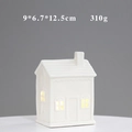 Detail view of a white ceramic house ornament with warm LED light and hollow design - YCSQ2280 Glossy White