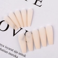 Detailed view of matte beige long coffin press-on nails arranged on a white paper background - Sheer Nude