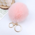 Nahaufnahme eines flauschigen rosa Pelz-Schlüsselanhängers mit goldenem Karabinerhaken - 8cm Kaninchenpelz-Imitat-Ball / Koreanisches Rosa