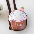 Detail view of a 3D cupcake shape kids backpack with strawberry charm and polka dots - Brown