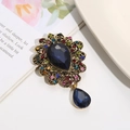 Detail of vintage blue waterdrop gemstone brooch with multicolor crystals on an antique base - Dark Blue