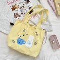 Detail der gelben Canvas-Tasche mit Hasenstickerei und seitlichem Kordelzugverschluss - Teetasse Kaninchen / Gelb