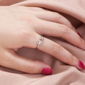 Detail of silver double cross open ring worn against a pink silk fabric background - Double X Cross Style (SE890)