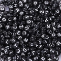 Macro view of black acrylic alphabet beads with white letters for DIY jewelry making - 4*7mm / 4x7mm Black With White Letters (100pcs)