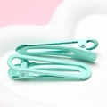 Pair of mint green U-shaped hair clips with a smooth matte finish on a heart tray - Teal Blue