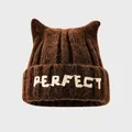 Detail view of thick brown knit hat with cat ears and Perfect embroidery for kids - Coffee